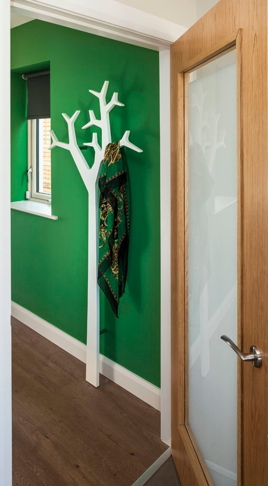 Idée de décoration pour un couloir design de taille moyenne avec un mur vert et sol en stratifié.