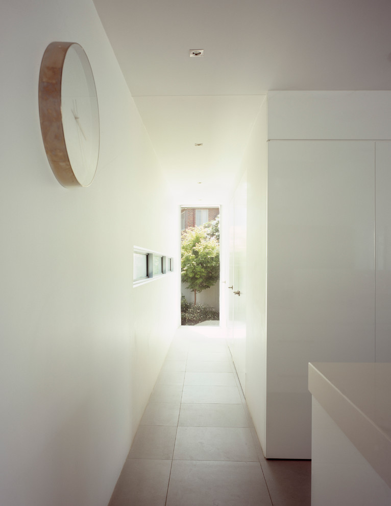 Cette photo montre un couloir tendance avec un mur blanc et un sol blanc.