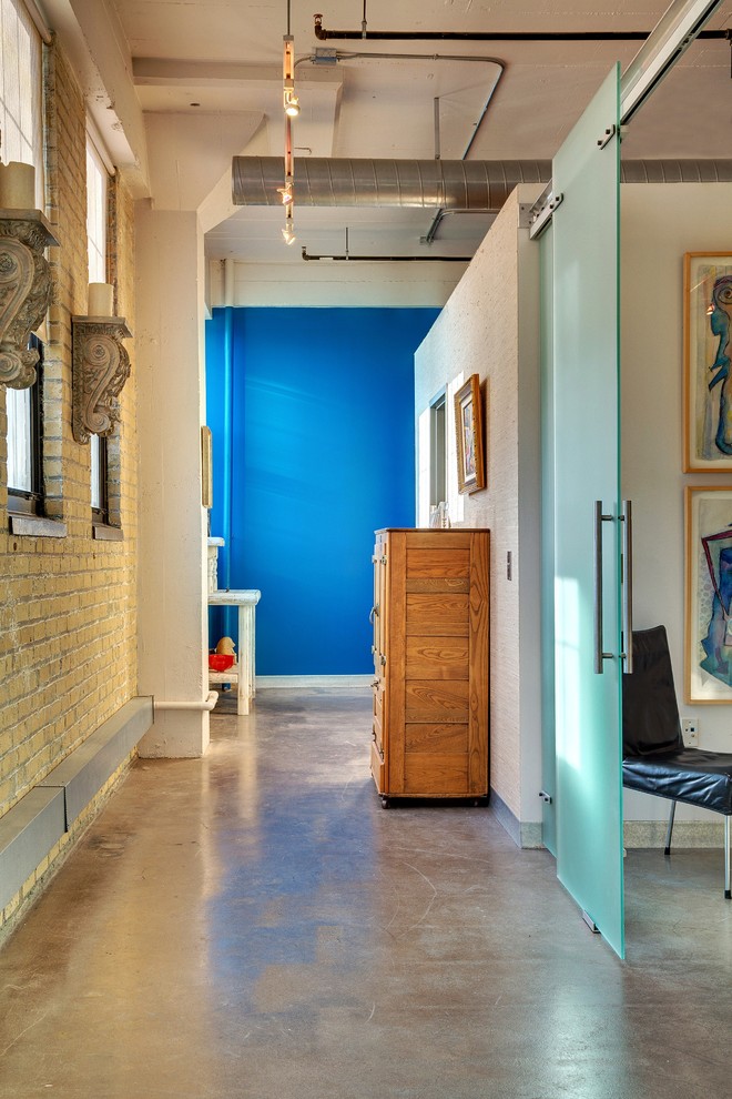 Foto di un ingresso o corridoio industriale con pareti blu e pavimento in cemento