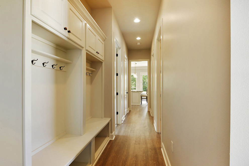 Idee per un ingresso o corridoio design di medie dimensioni con pareti beige, pavimento in legno massello medio e pavimento marrone