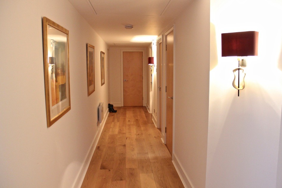На фото: узкий коридор среднего размера в современном стиле с белыми стенами и паркетным полом среднего тона с