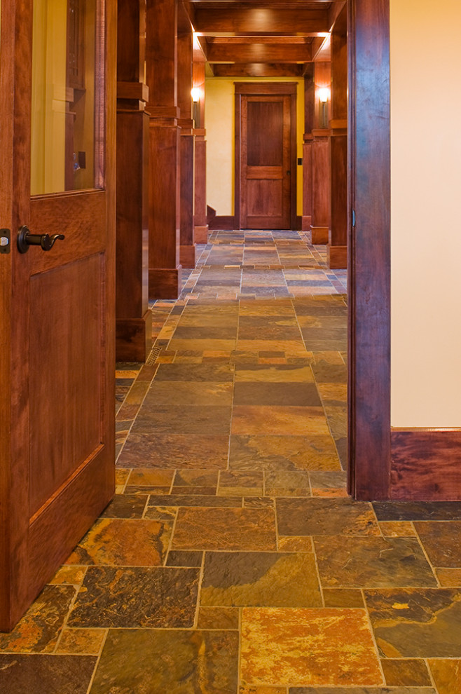 На фото: большой коридор в стиле кантри с бежевыми стенами, полом из сланца и разноцветным полом с