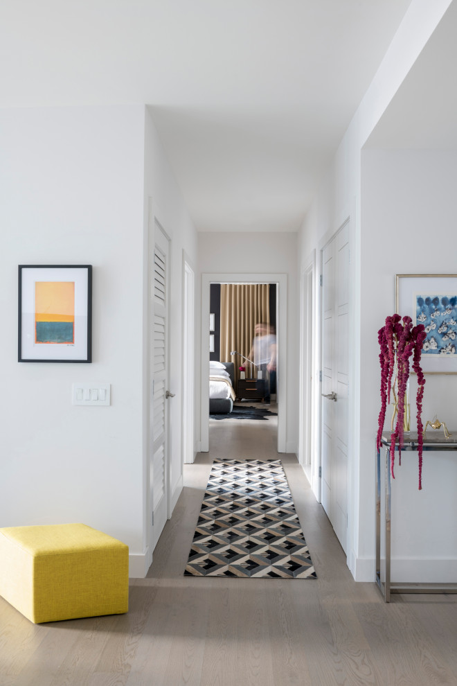 Ispirazione per un ingresso o corridoio minimalista di medie dimensioni con pareti bianche, parquet chiaro e pavimento grigio