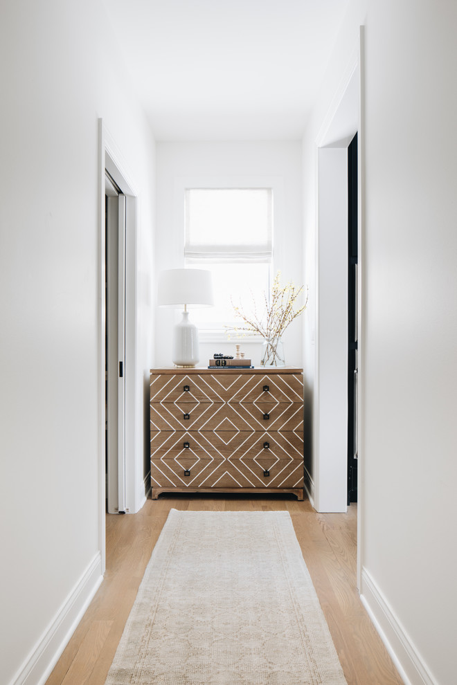 Inspiration pour un petit couloir traditionnel avec un mur blanc, parquet clair et un sol marron.