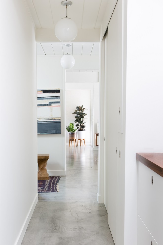Example of an eclectic concrete floor hallway design in San Francisco with white walls