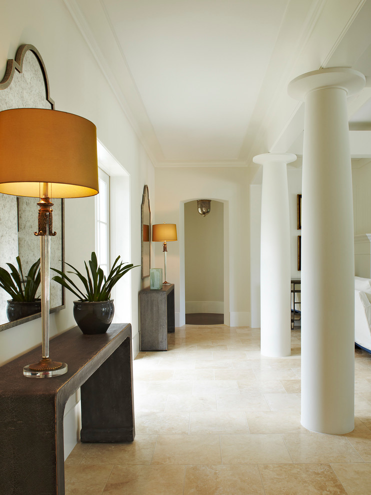 Cette image montre un couloir minimaliste de taille moyenne avec un mur beige, un sol en calcaire et un sol beige.