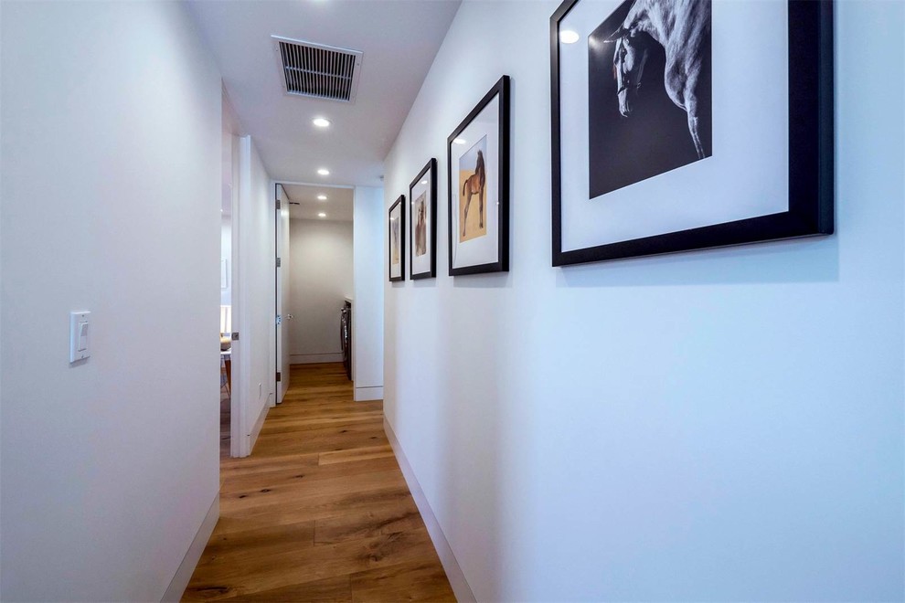 Mittelgroßer Moderner Schmaler Flur mit weißer Wandfarbe, braunem Holzboden und braunem Boden in Los Angeles