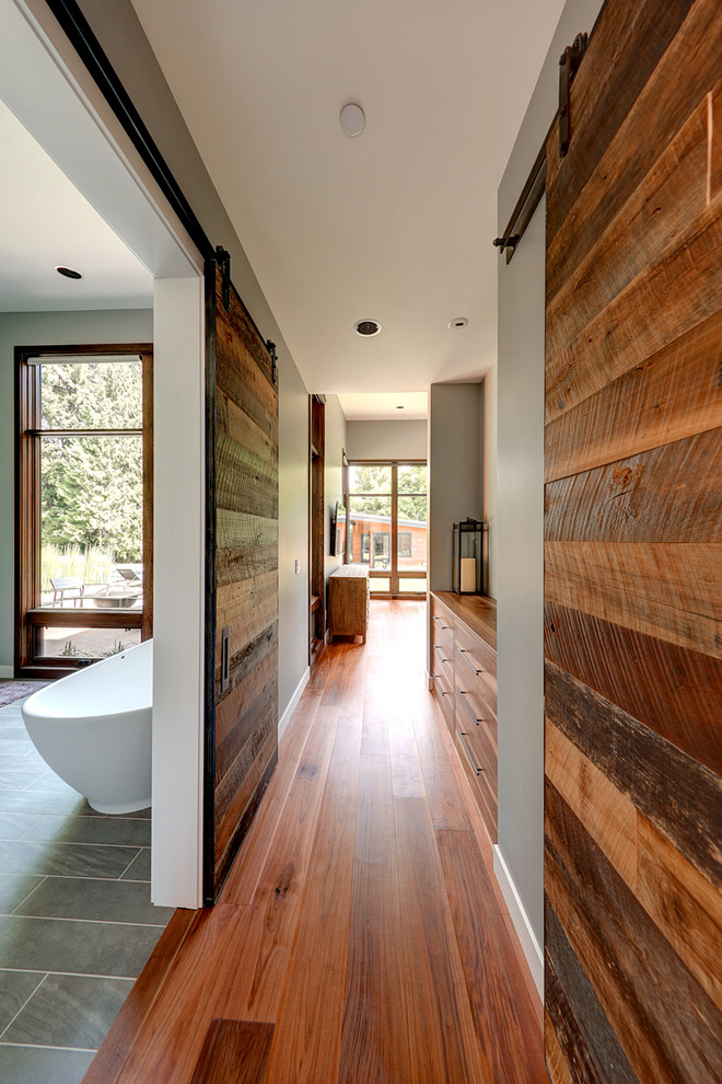 Hallway - large rustic medium tone wood floor hallway idea in Portland with gray walls