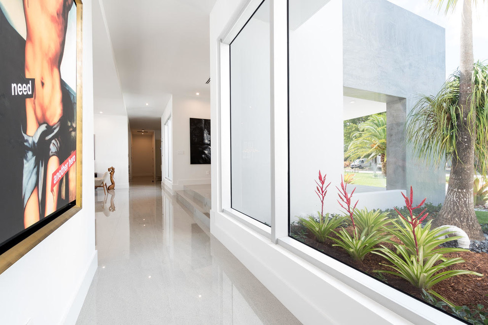 Hallway - mid-sized modern concrete floor and gray floor hallway idea in Miami with white walls