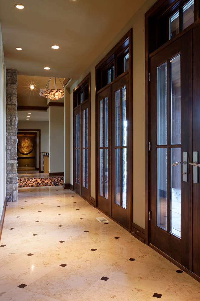 Hallway - huge contemporary limestone floor hallway idea in Omaha with beige walls