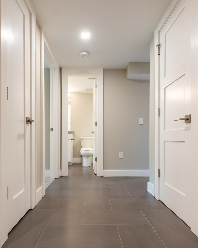 Стильный дизайн: коридор среднего размера в стиле неоклассика (современная классика) с серыми стенами, полом из керамогранита и черным полом - последний тренд