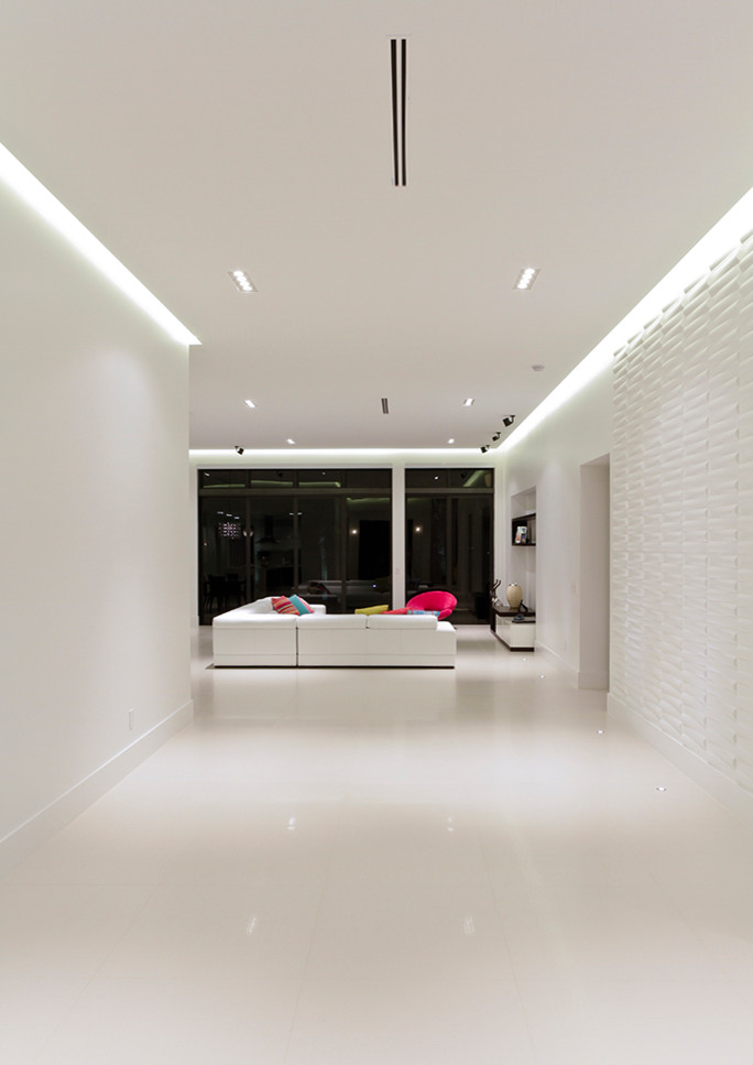 Bild på en stor funkis hall, med vita väggar, betonggolv och vitt golv