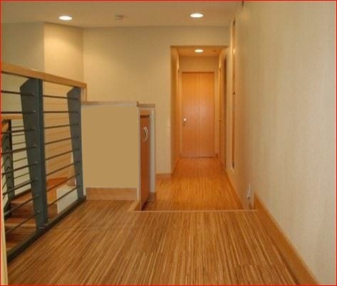 На фото: большой коридор в стиле модернизм с желтыми стенами, полом из бамбука и бежевым полом