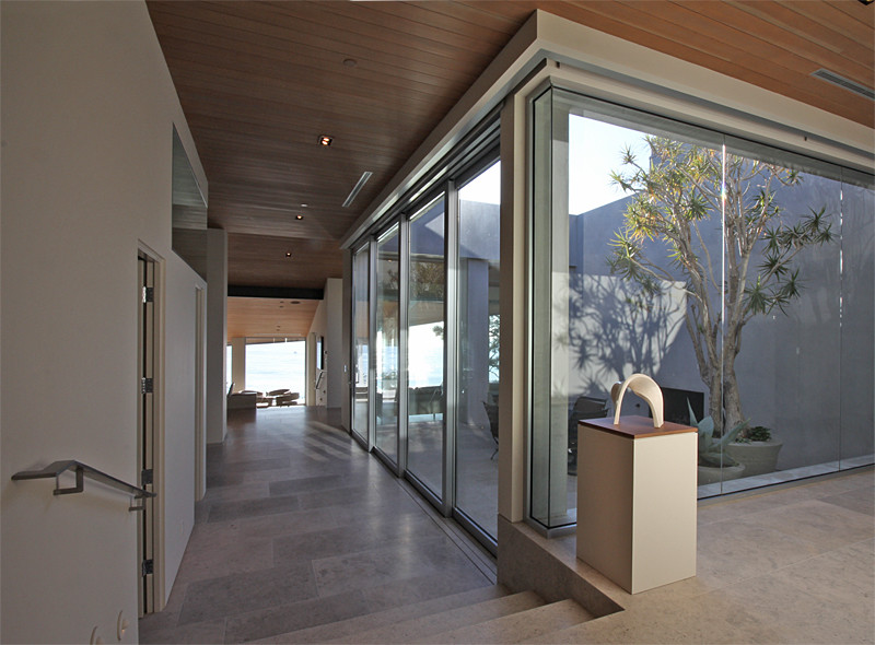 Inspiration pour un grand couloir design avec un mur gris et un sol en calcaire.