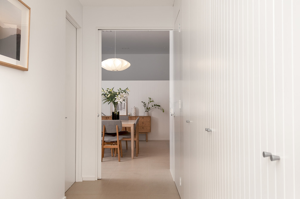 Cette image montre un couloir vintage de taille moyenne avec un mur blanc et un sol en carrelage de céramique.