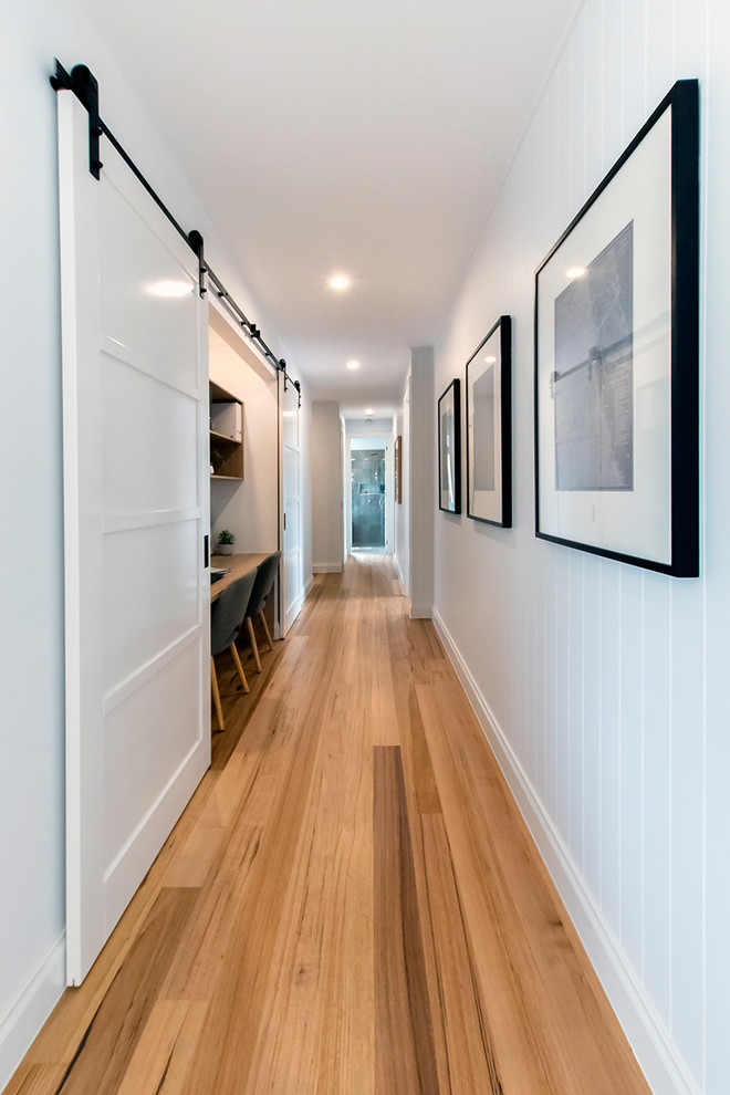 Country Flur mit weißer Wandfarbe, braunem Holzboden und braunem Boden in Melbourne