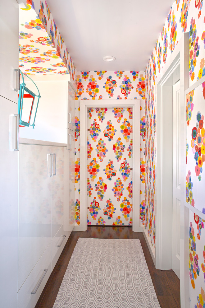 Cette photo montre un couloir tendance avec un mur multicolore et parquet foncé.