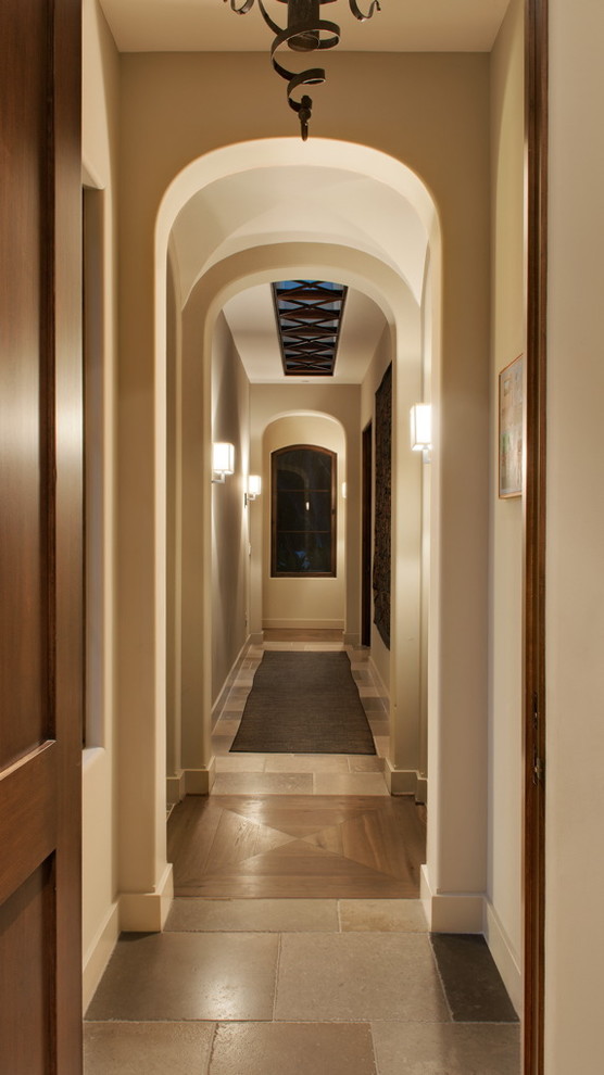 Hallway - large mediterranean travertine floor hallway idea in Santa Barbara with white walls