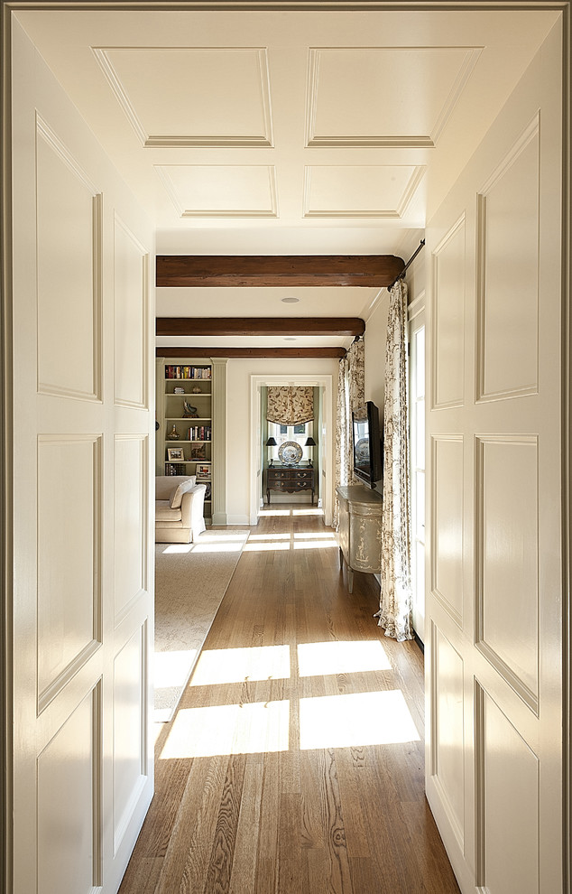 Mid-sized elegant medium tone wood floor hallway photo in Dallas with white walls