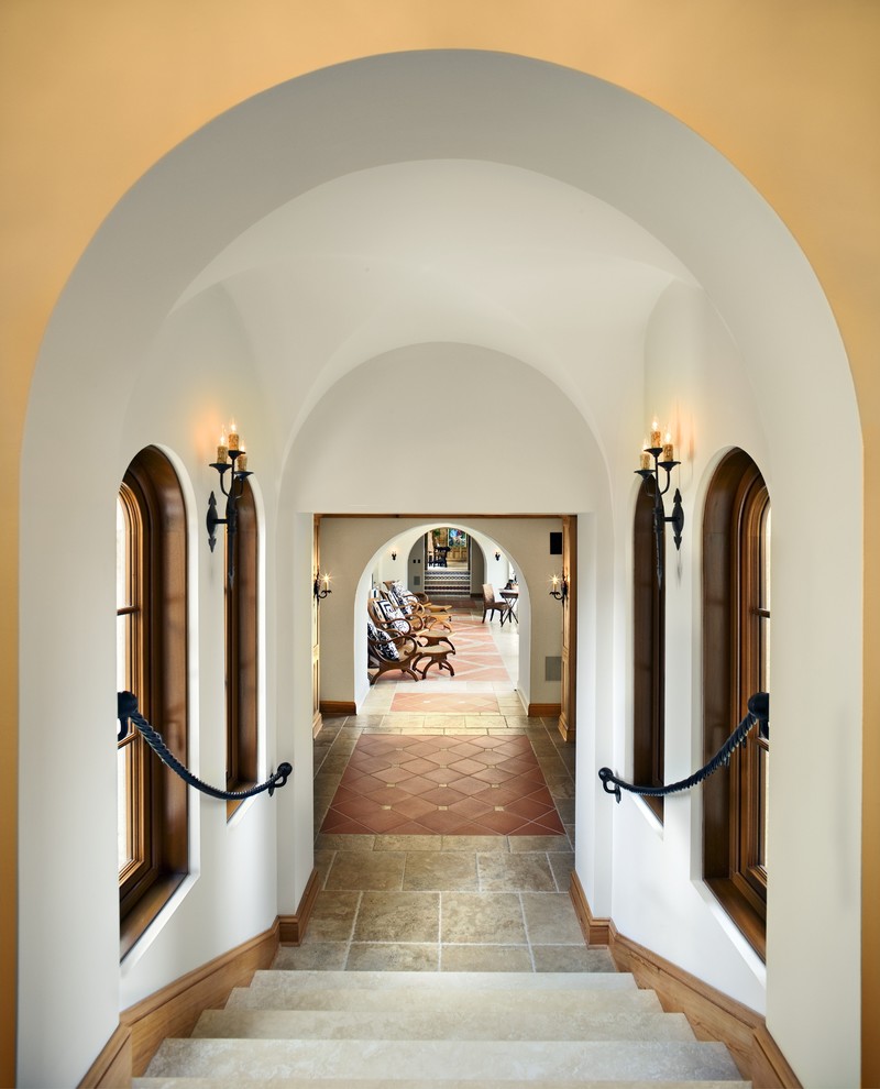 Cette photo montre un grand couloir méditerranéen avec un mur blanc et un sol en carrelage de porcelaine.