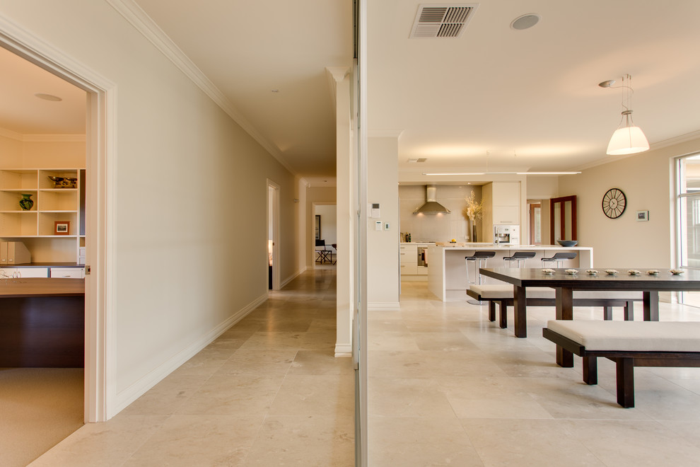 Idées déco pour un grand couloir moderne avec un mur beige et un sol en travertin.