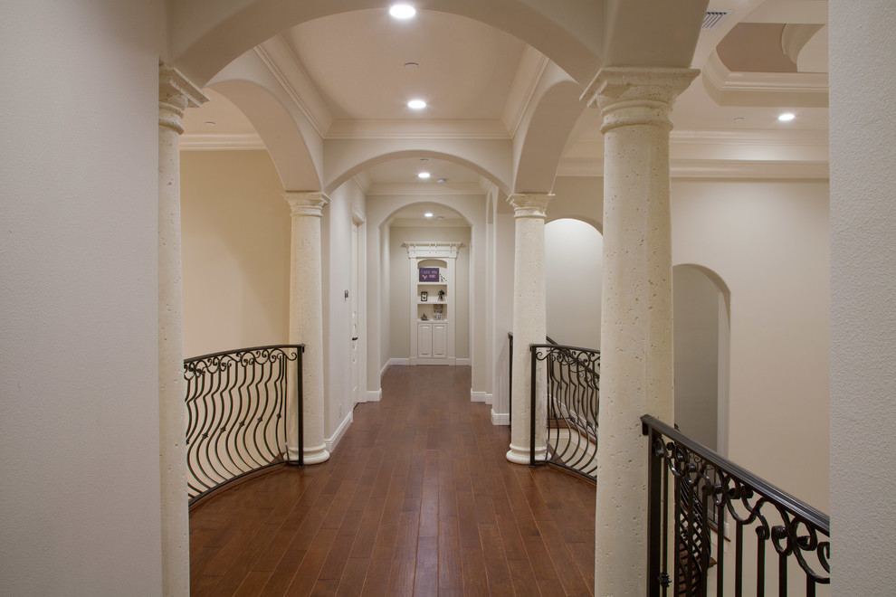 Ejemplo de recibidores y pasillos mediterráneos grandes con suelo de madera en tonos medios y paredes beige