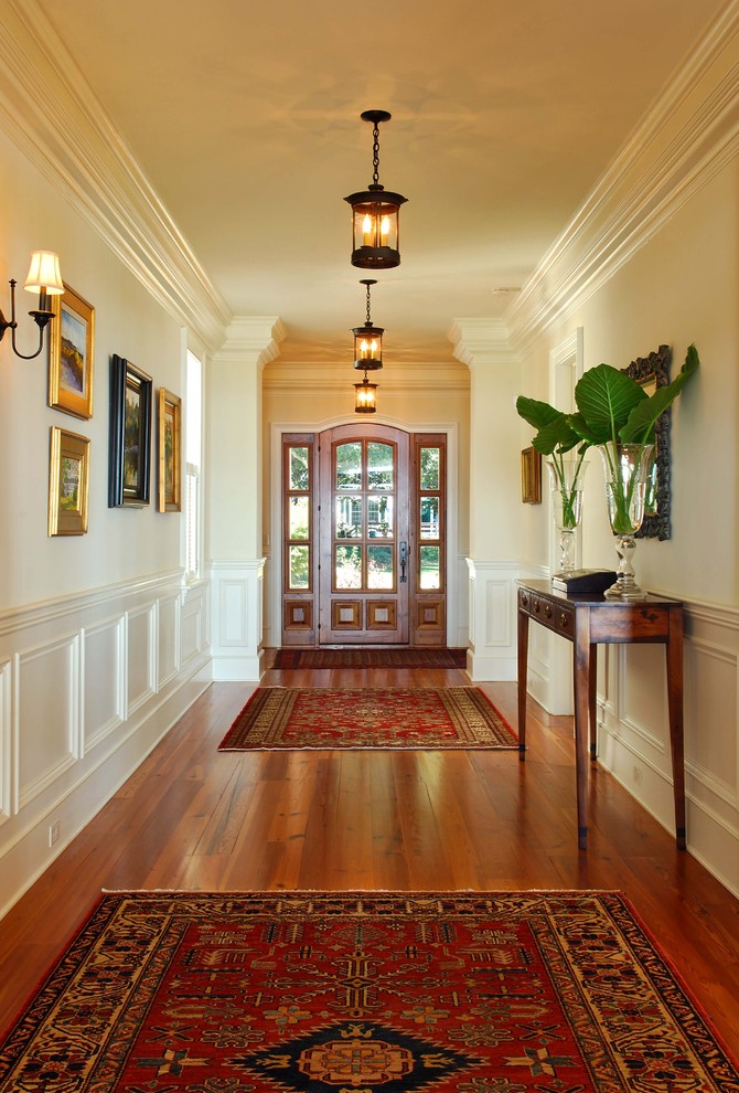 Ispirazione per un ingresso o corridoio classico con pareti bianche e pavimento in legno massello medio