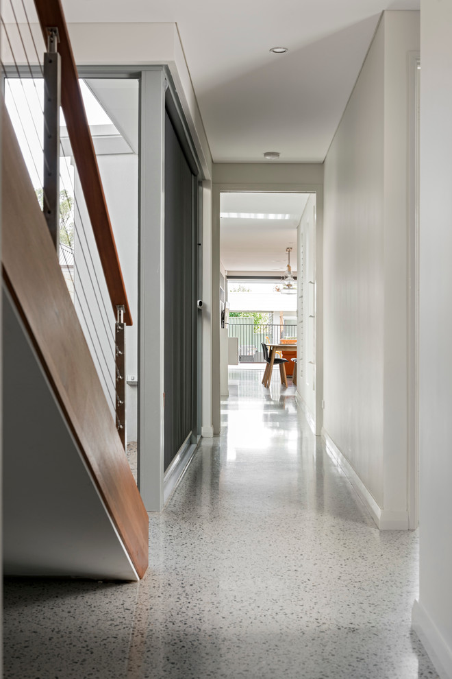 Idee per un ingresso o corridoio contemporaneo di medie dimensioni con pareti bianche e pavimento in cemento
