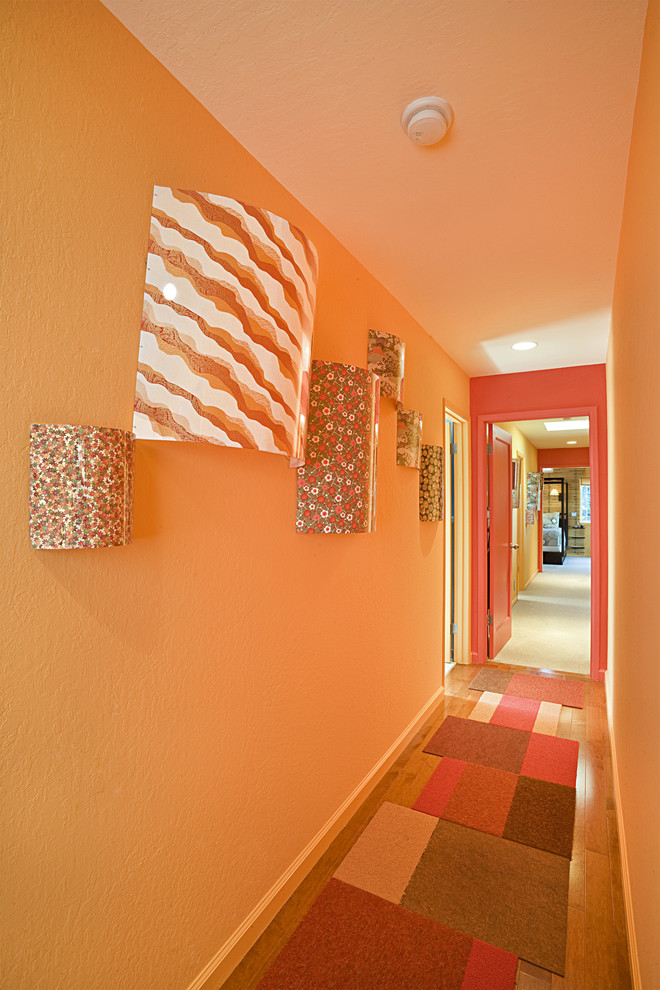 Inspiration för moderna hallar, med orange väggar, mellanmörkt trägolv och orange golv