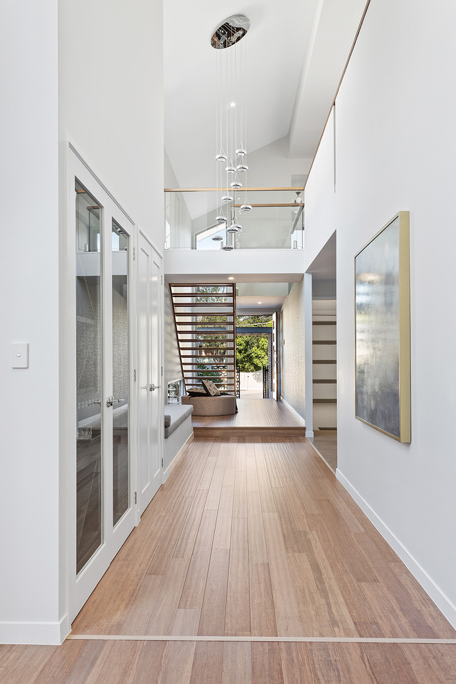 Стильный дизайн: большой коридор в современном стиле с белыми стенами и полом из бамбука - последний тренд