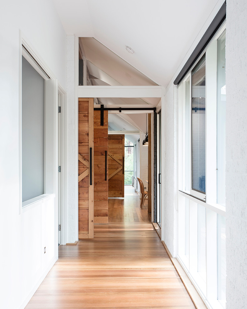 Ejemplo de recibidores y pasillos de estilo de casa de campo de tamaño medio con suelo de madera clara