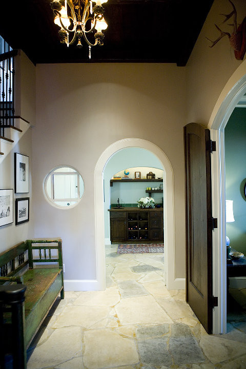 На фото: коридор среднего размера в викторианском стиле с серыми стенами, полом из известняка и бежевым полом с