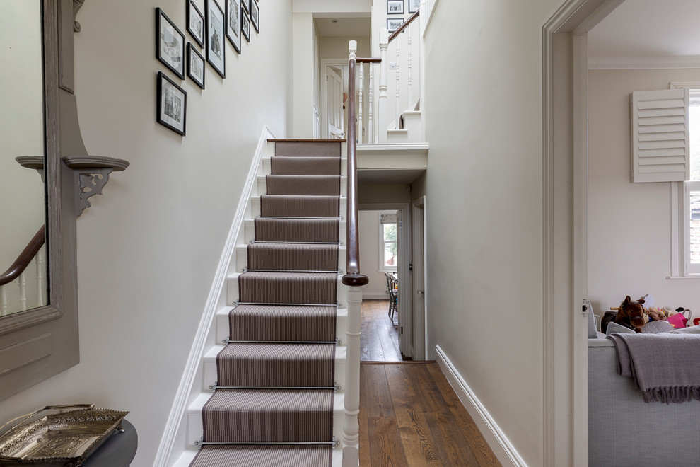 Inspiration for a medium sized traditional carpeted l-shaped wood railing staircase in London with carpeted risers.