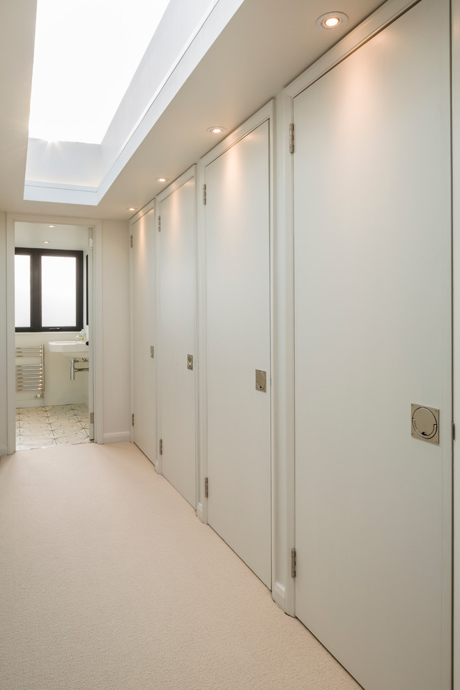 Cette image montre un couloir design avec un mur blanc et moquette.