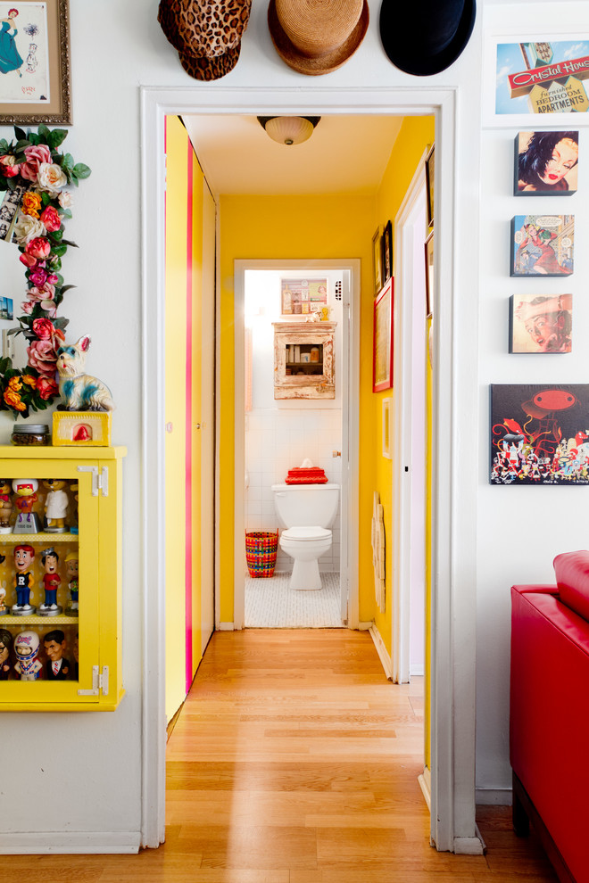 На фото: коридор в стиле фьюжн с желтыми стенами и паркетным полом среднего тона