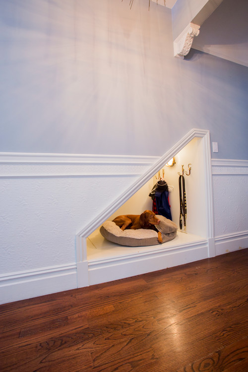 The space beneath the stairs was transformed into a cozy spot for the dog's bed and leash storage.