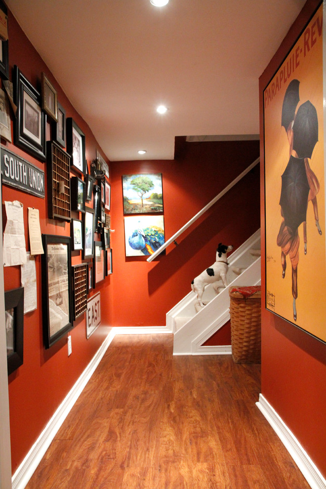 トロントにあるエクレクティックスタイルのおしゃれな廊下 (赤い壁、濃色無垢フローリング、茶色い床) の写真