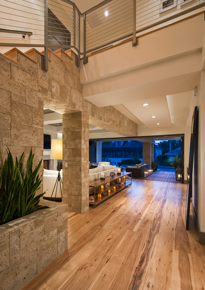 Inspiration for a mid-sized modern light wood floor hallway remodel in Miami with beige walls