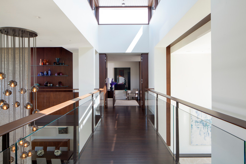 Inspiration for a contemporary dark wood floor and brown floor hallway remodel in Los Angeles with white walls