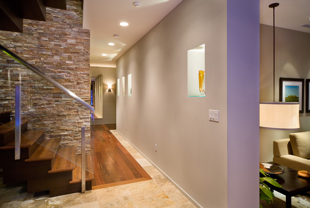 Modelo de recibidores y pasillos actuales con paredes grises, suelo de madera en tonos medios y suelo multicolor