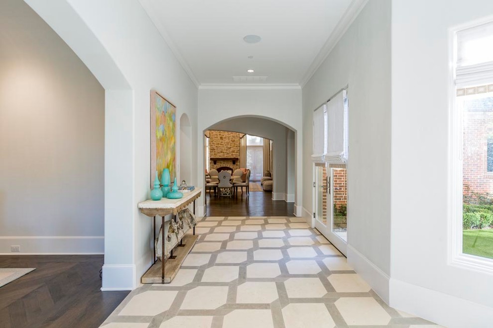 ダラスにあるラグジュアリーな広いトランジショナルスタイルのおしゃれな廊下 (グレーの壁、トラバーチンの床、ベージュの床) の写真