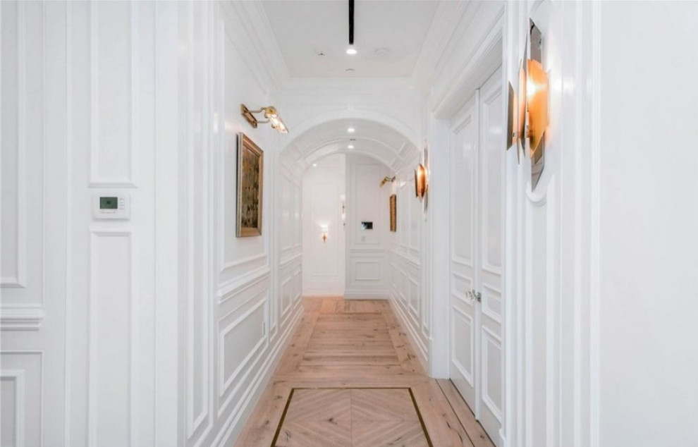 На фото: коридор среднего размера в стиле неоклассика (современная классика) с белыми стенами, светлым паркетным полом и бежевым полом