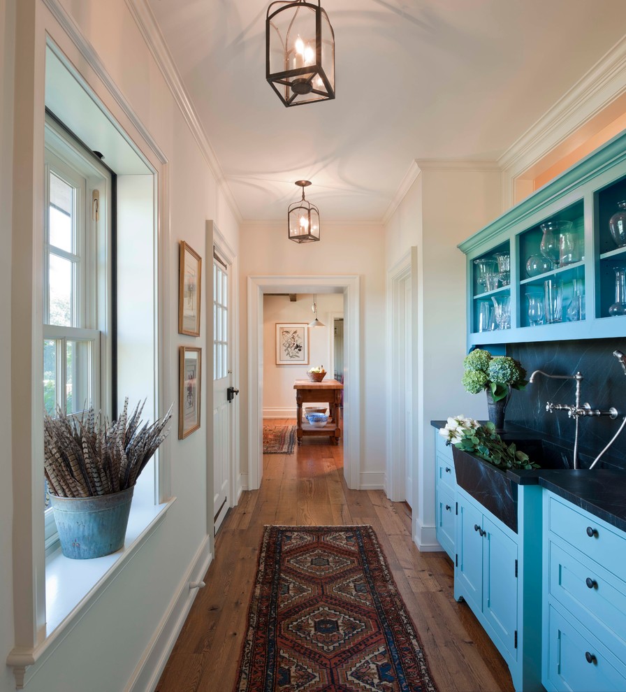 Example of a country medium tone wood floor hallway design in Philadelphia with white walls