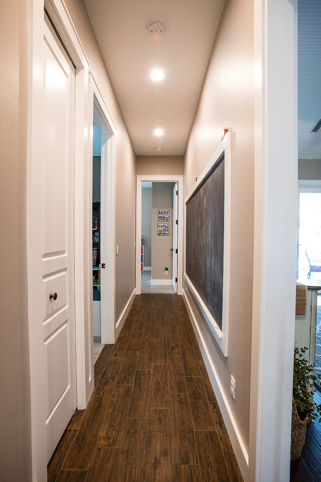 Immagine di un ingresso o corridoio stile americano di medie dimensioni con pareti beige, pavimento in legno massello medio e pavimento marrone