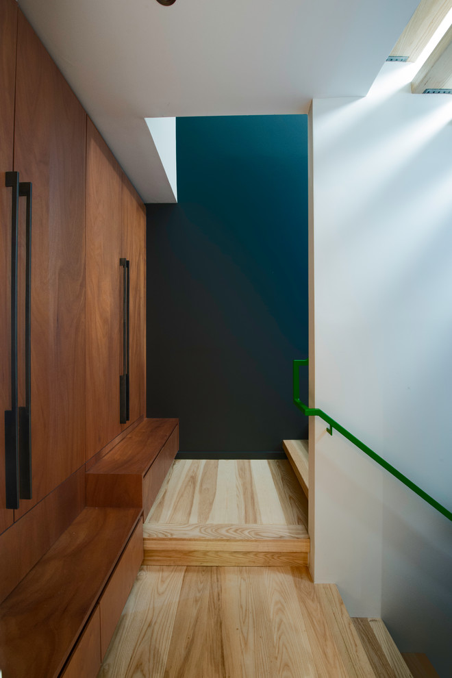 Idées déco pour un couloir contemporain en bois de taille moyenne avec un mur blanc, parquet clair, un sol marron et un plafond voûté.