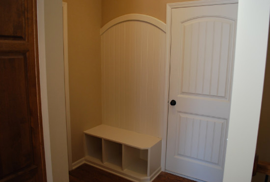 Example of a small classic medium tone wood floor hallway design in Kansas City with beige walls