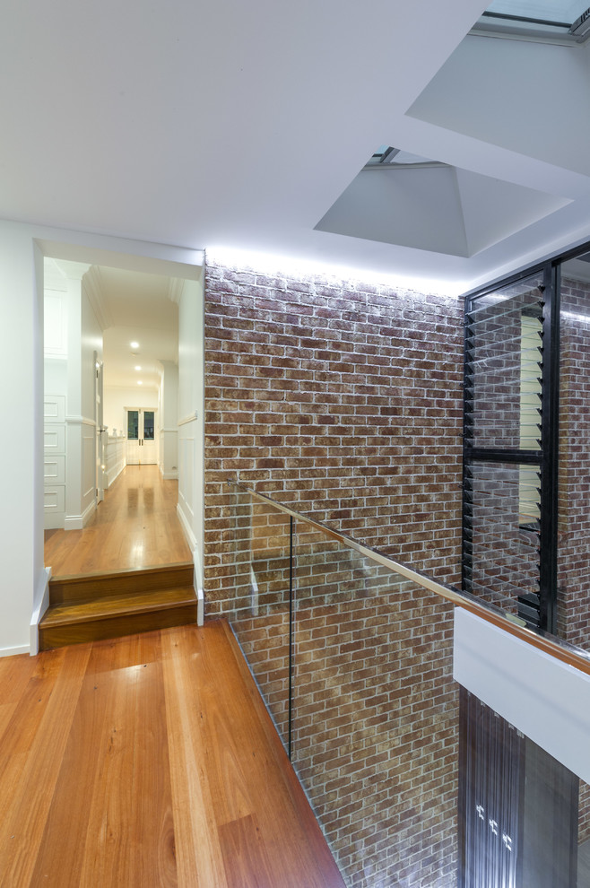 Moderner Flur mit weißer Wandfarbe und braunem Holzboden in Brisbane