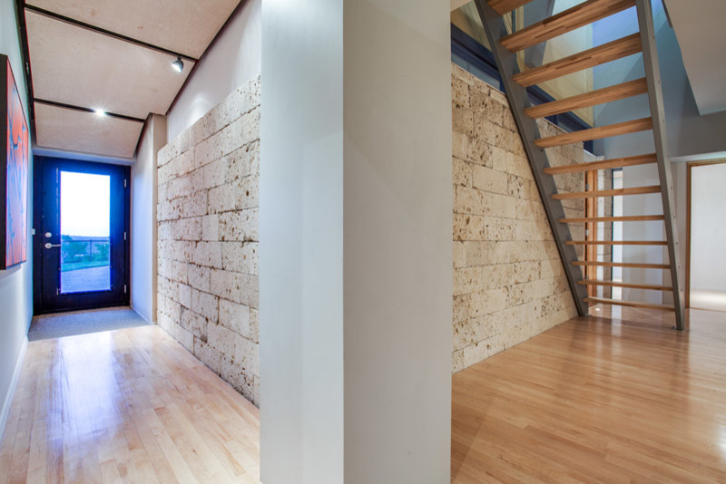 Ejemplo de recibidores y pasillos modernos de tamaño medio con paredes multicolor y suelo de madera clara