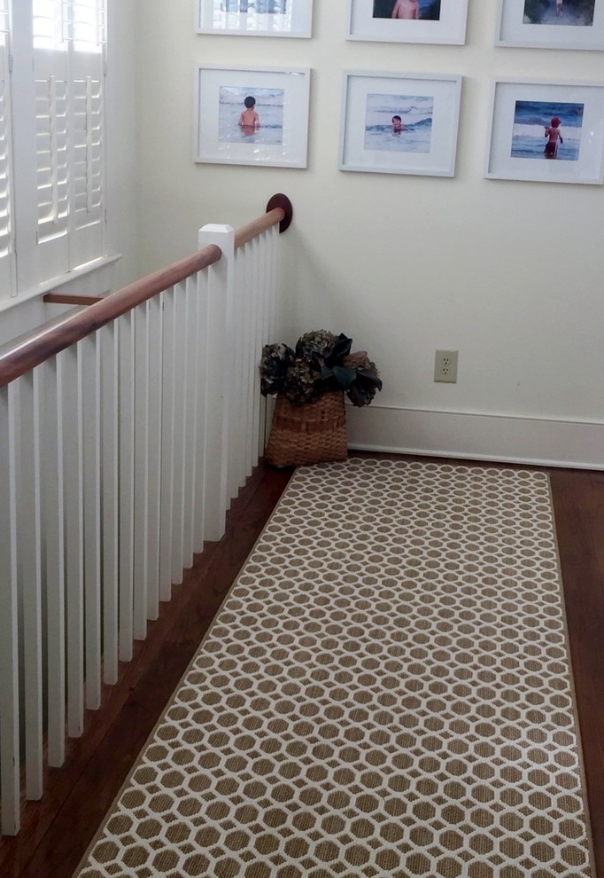 Réalisation d'un couloir champêtre de taille moyenne avec un mur blanc et un sol en bois brun.
