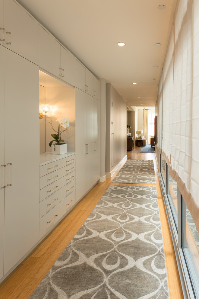 Großer Moderner Flur mit beiger Wandfarbe, hellem Holzboden und braunem Boden in New York